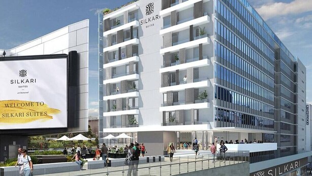 A modern hotel building with a prominent sign reading "Silkari Suites."