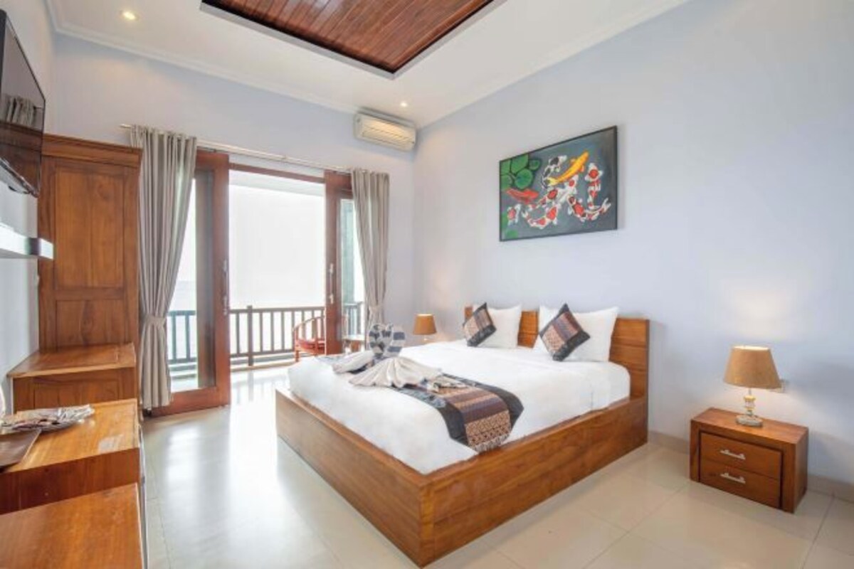 A modern bedroom with a wooden bed, a nightstand, a desk, and a large window with curtains.