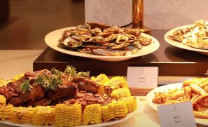 Savor a diverse selection of dishes, including grilled corn, meat entrées, seafood, and potato wedges.
