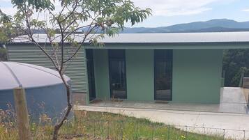 Situated in a natural setting, this building features large windows and a green facade.