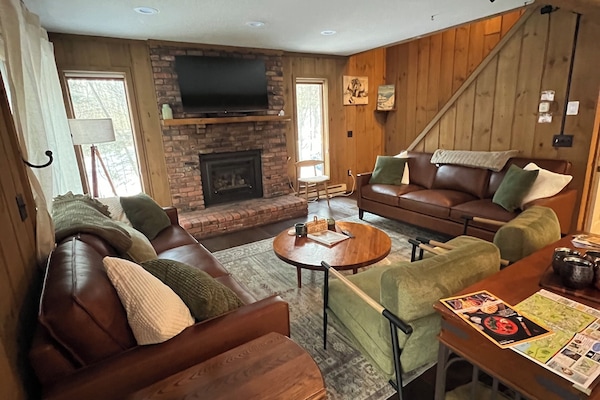 Cozy main level living room has seating for 8, a gas fireplace, and smart tv.