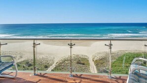 Un balcon offrant une vue dégagée sur l’océan et la plage.