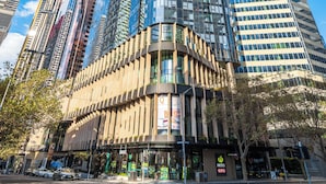 A modern skyscraper with a curved glass facade, surrounded by other high-rise buildings.