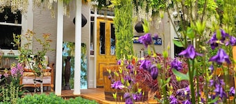 Cozy, beautifully decorated cottage sitting in a stunning seasonal garden