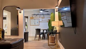 A modern living room with a sofa, chairs, a dining table, and a ceiling fan. - Siesta Key Cottage – Best Value! Just Cross the Street to the Gulf! (Siesta Key)