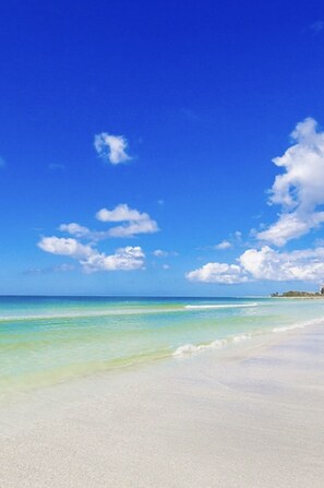 Ein Strand mit klarem türkisblauem Wasser und einem weißen Sandstrand.