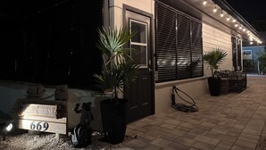 A house with a sign reading "Beach House 669," a large planter, and outdoor lighting. - Siesta Key Cottage – Best Value! Just Cross the Street to the Gulf! (Siesta Key)