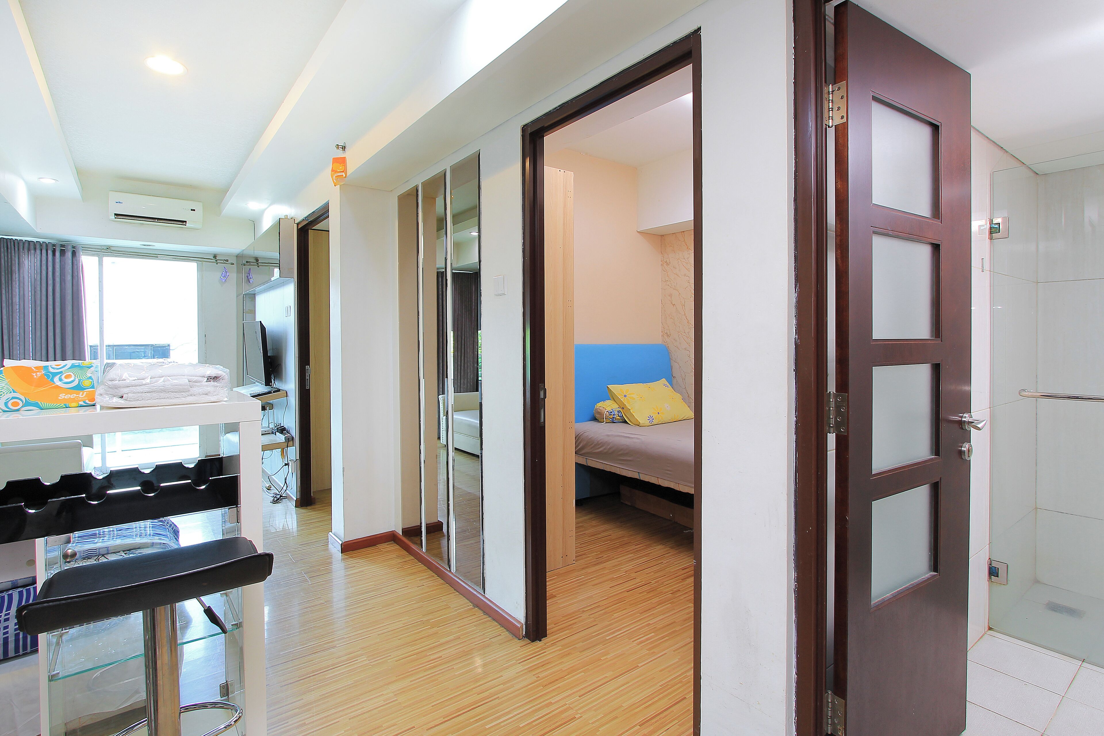 A hotel room with a bed, a bathroom, and a kitchenette area.