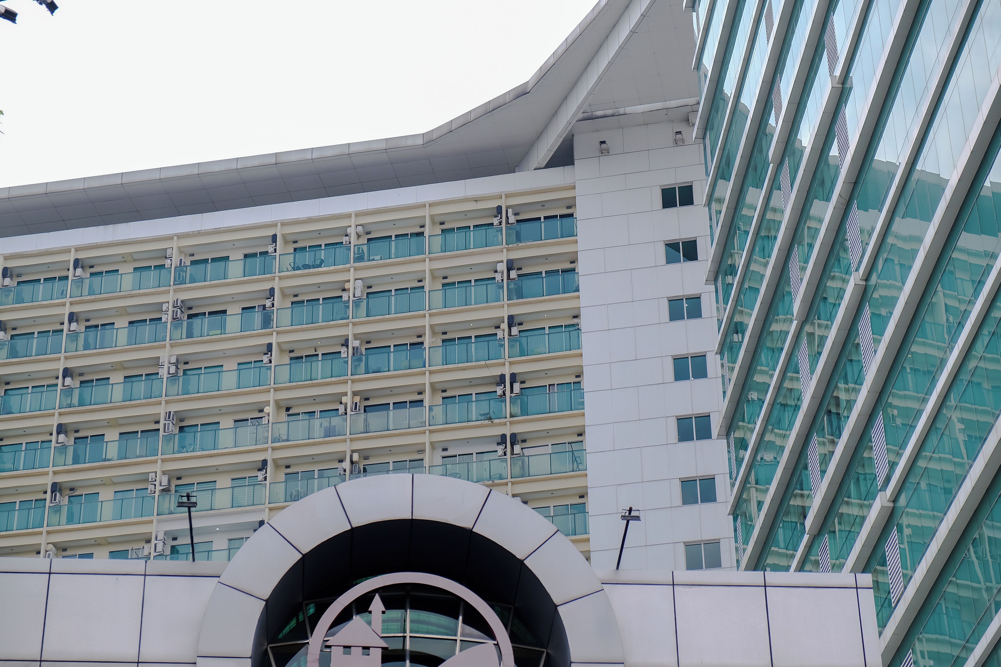 A modern building with multiple floors, large windows, and a distinctive arched entrance.