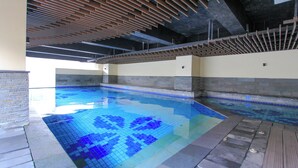A swimming pool with blue mosaic tiles, a wooden ceiling, and a tiled floor. - La Grande by Djitu Hospitality (Bandung)