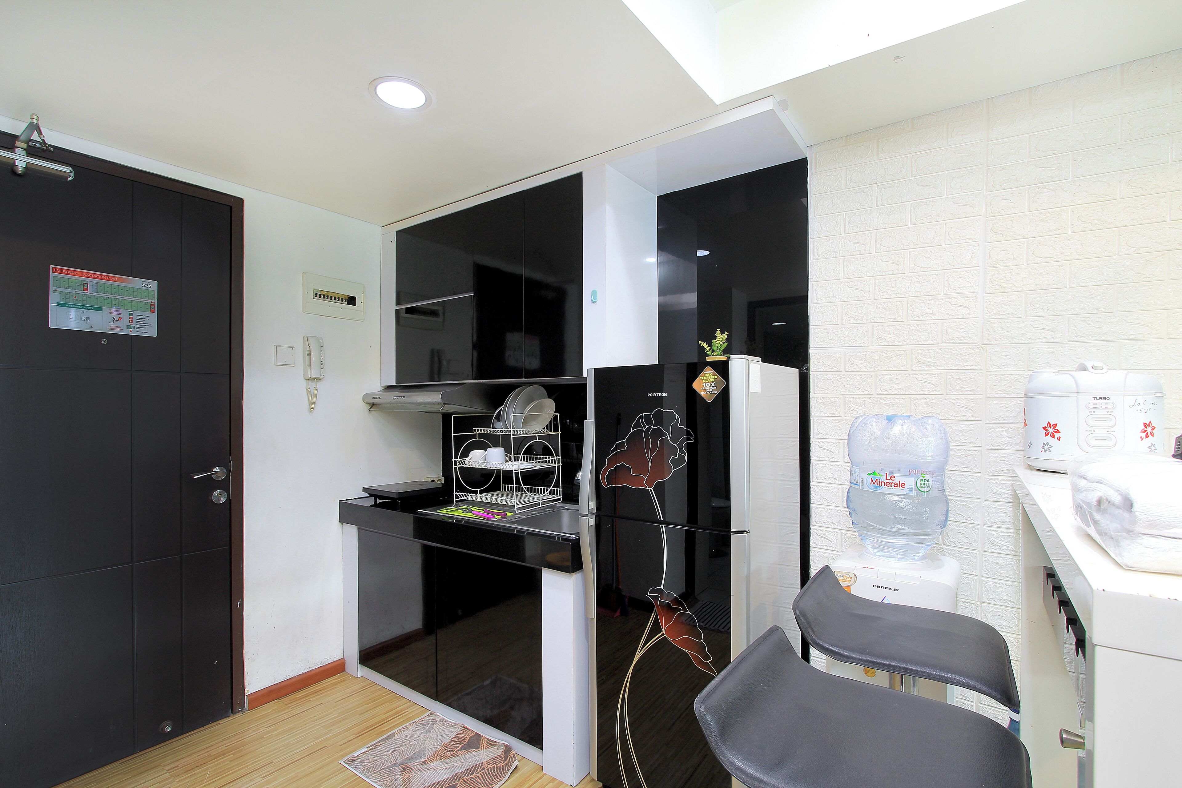 Una cocina moderna con refrigerador, dispensador de agua y lavabo.