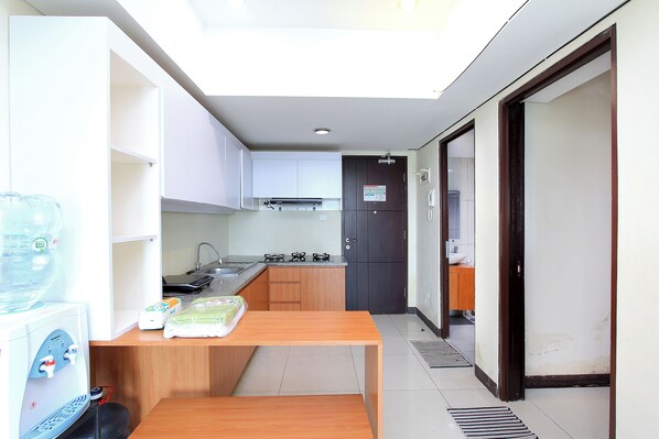 A compact kitchen with a built-in stove, a sink, and a water dispenser.