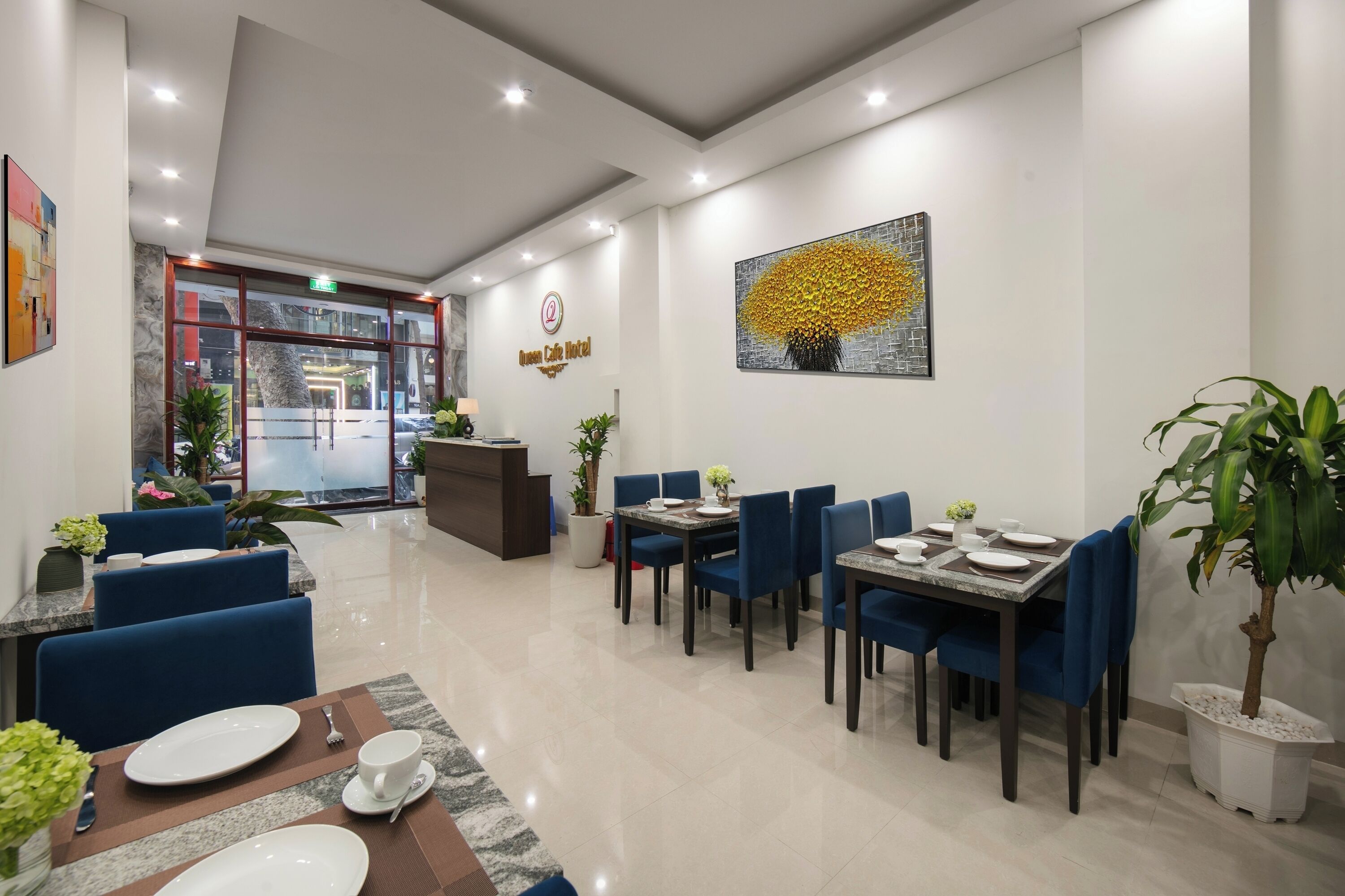 Un hall de hotel con mostrador de recepción, zona de estar y comedor.