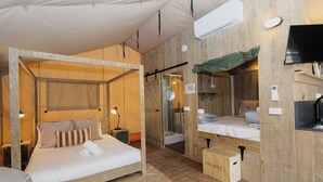 Une chambre chaleureuse, décorée dans un style rustique avec du bois, comprenant deux lits, un téléviseur et un espace douche.