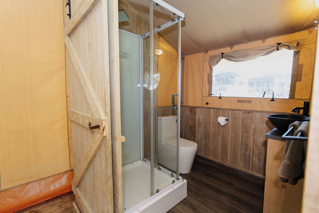 Un baño pequeño con cabina de ducha, inodoro y lavamanos.
