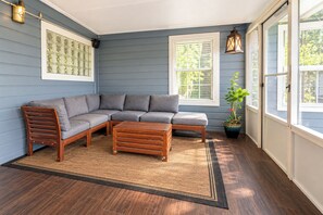 A room with a sectional sofa, a wooden coffee table, a potted plant, and a window with blinds. - Pool, Spa, Bar + Game Room - Huntsville Lake House (Huntsville)
