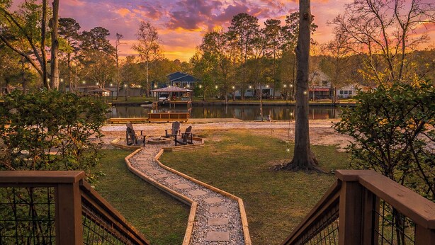 A lakeside view with a wooden deck, a dock, and a gazebo. - Pool, Spa, Bar + Game Room - Huntsville Lake House (Huntsville)