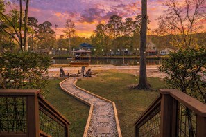 A lakeside view with a wooden deck, a dock, and a gazebo. - Pool, Spa, Bar + Game Room - Huntsville Lake House (Huntsville)