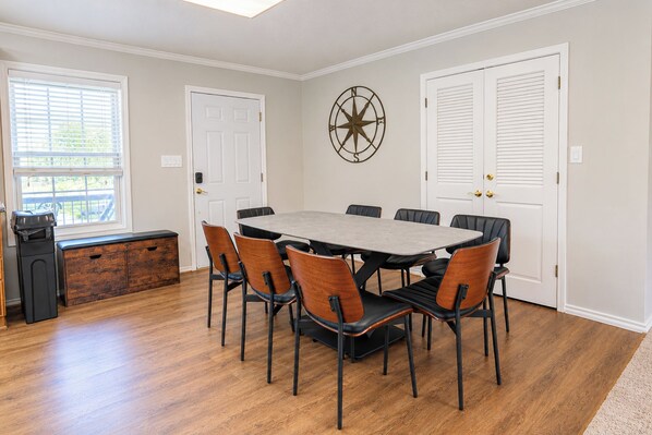 A dining area with a rectangular table, six chairs, and a wooden cabinet.