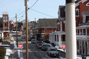 Vista de calle con edificios residenciales, una iglesia y una señal de 'Wrong Way'.