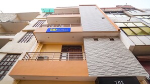 A multi-story hotel with a sign for 'Fab Hotels' and 'The Pleasure Stay'. - Fabhotel The Pleasure Stay (Varanasi)