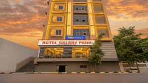 A modern hotel building with a sign for 'Hotel Galaxy Park' and 'FabHotels'.