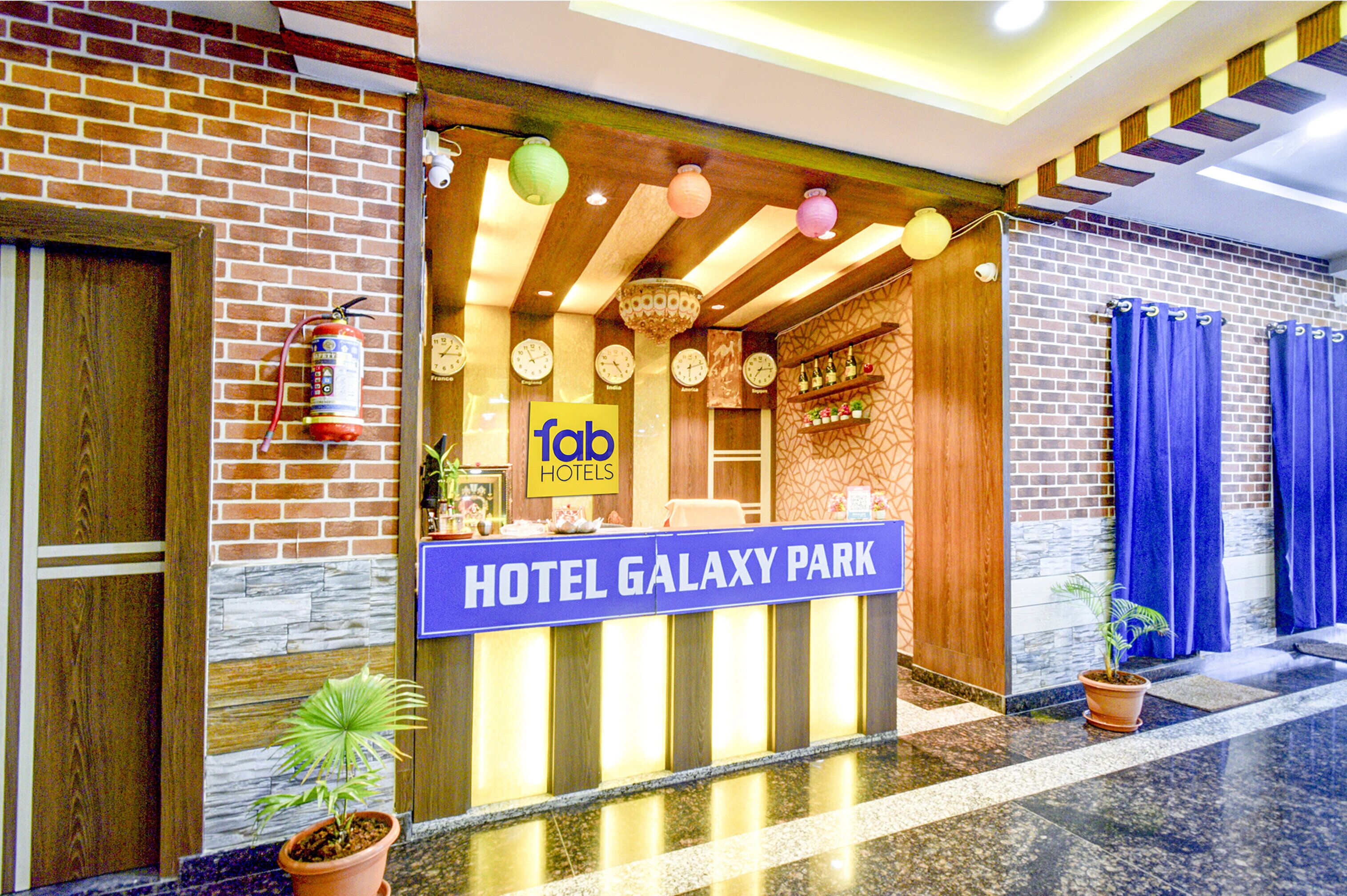A hotel entrance with a sign reading "HOTEL GALAXY PARK" and a reception desk.