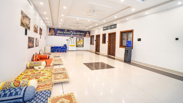 A spacious hotel lobby with a high ceiling, recessed lighting, and a central seating area with patterned cushions. - Fabhotel Shree Radha Ashtami Seva Ashram (Mathura)
