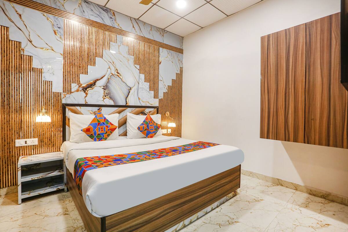 A modern bedroom with a wooden headboard, a patterned wall, and a built-in shelf.