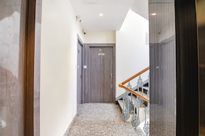 A hallway with a wooden door labeled "ROOM NO 301" and a staircase with a metal railing. - Fabhotel City Star (Bidhannagar)