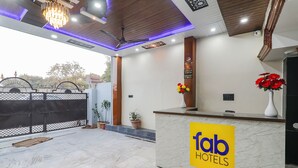 A reception area with a marble counter, a chandelier, and a ceiling fan. - Fabhotel Awadh Inn - 600 m from Ram mandir (Ayodhya)