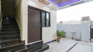A modern entrance with a dark wooden door, a marble staircase, and a potted plant. - Fabhotel Awadh Inn - 600 m from Ram mandir (Ayodhya)