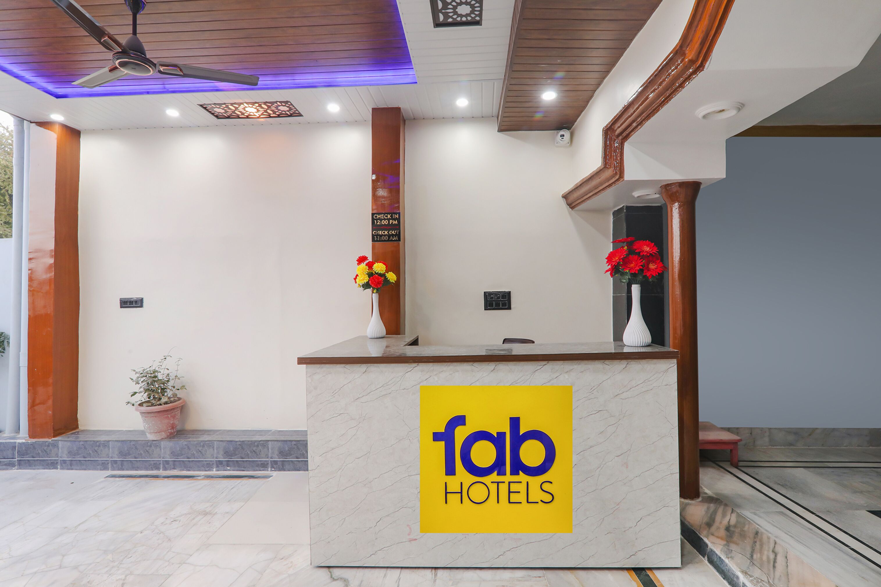 A reception desk with a marble top and a 'fab hotels' sign.