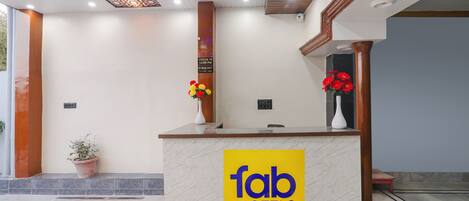 A reception desk with a marble top and a 'fab hotels' sign.