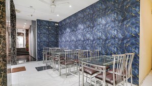 A dining area with a modern design, featuring a patterned wall and a ceiling fan. - Fabhotel Powai Inn (Mumbai)