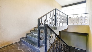 A staircase with marble steps and ornate black metal railings.