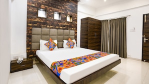 A modern bedroom with a large bed, a wooden headboard, and a built-in wardrobe.