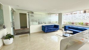 A modern lobby with a blue sofa, a glass coffee table, and a potted plant. - Fabhotel Maski Suites (Hyderabad)
