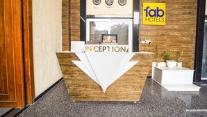 Un mostrador de recepción con un fondo de madera y un letrero que dice 'fab hotels' arriba.
