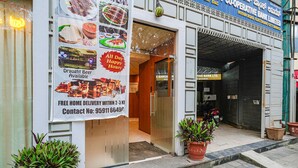 A storefront with a sign advertising draught beer and free home delivery. - FabHotel Prime The Vintage Inn - Hosur Road (Bengaluru)