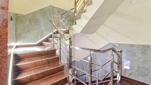 A staircase with metal railings and granite steps. - Fabhotel Heaven Palace (Haridwar)