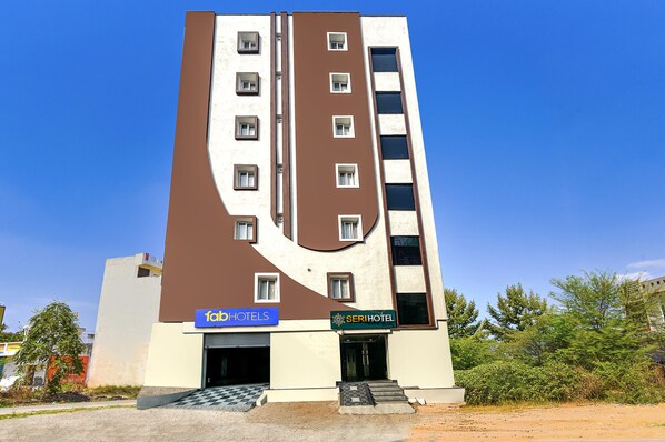A modern hotel with a unique architectural design, featuring a central vertical element and multiple windows. - Fabhotel Seri (Hyderabad)