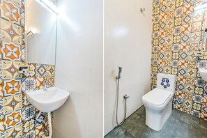 A bathroom with patterned tiles, a sink, and a toilet. - Fabhotel Seri (Hyderabad)