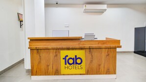 A reception desk with a wooden finish and a yellow sign reading "fab hotels". - Fabhotel Seri (Hyderabad)