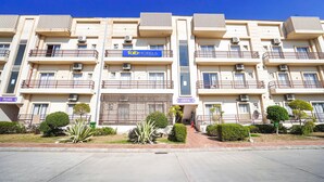 Un hôtel à plusieurs étages, doté de balcons, de climatiseurs et d’une enseigne indiquant « Tab Hotels ».