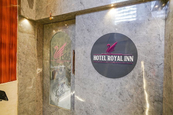 A marble wall with a circular sign for the HOTEL ROYAL INN.