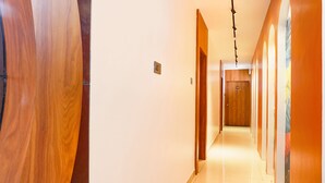 Un couloir avec des portes en bois et un intérieur lumineux et bien éclairé.