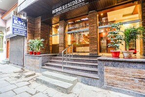 A hotel entrance with a sign for KSG Residency, a staircase leading up to the entrance, and potted plants on the steps. - Fabhotel Ksg Residency (Varanasi)