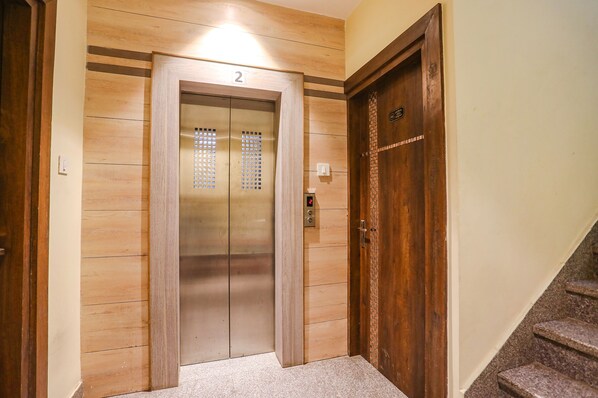 An elevator with a wooden finish and a number '2' on the door.