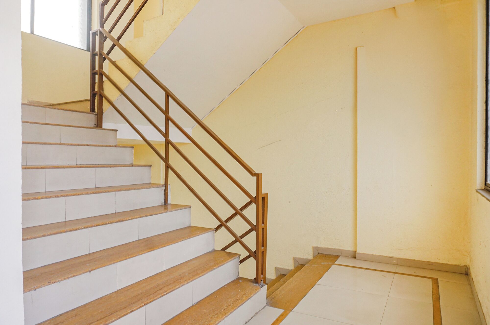 A staircase with wooden steps and metal railings leading to a landing.